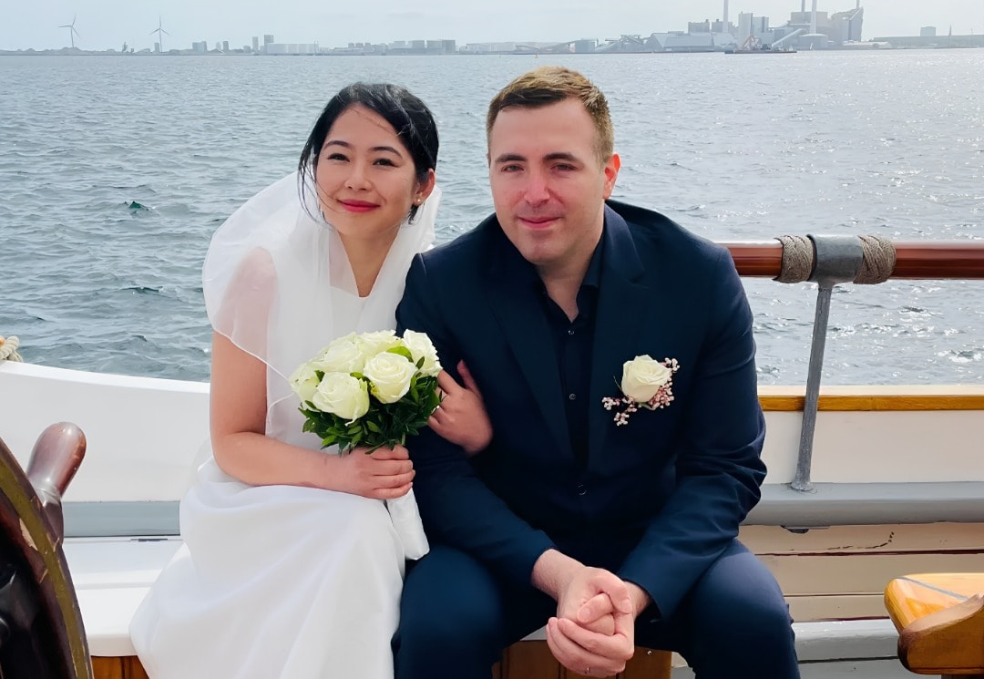 Alexander und Thi Yen im Hochzeitsoutfit auf einem Boot im Kopenhagener Hafen.